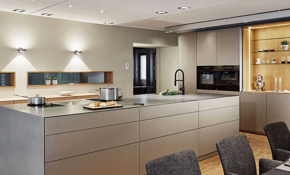 Große Kücheninsel mit Küchengeräten und an der Wand liegenden Schränken  Große Kücheninsel mit Küchengeräten und an der Wand liegenden Schränken