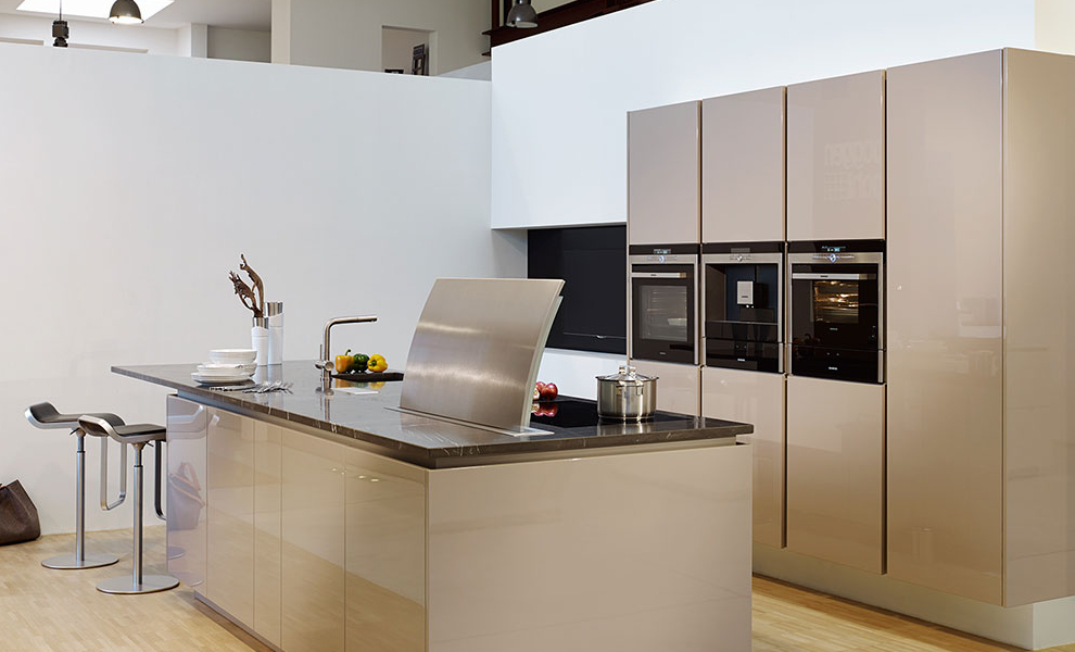 Beige Küche mit Insel und Wandschränken. Küchengeräte in der Insel und kleiner Theke  Beige Küche mit Insel und Wandschränken. Küchengeräte in der Insel und kleiner Theke