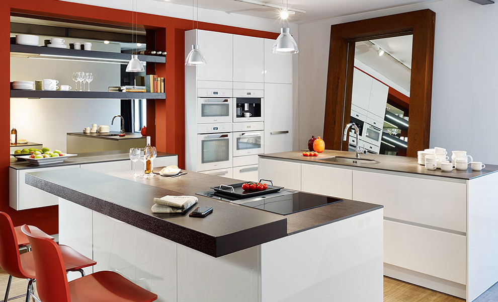 Rote Wand mit Weißen Küchenschränke, zwei Küchen Inseln als Arbeitsflächen und einer Theke  Rote Wand mit Weißen Küchenschränke, zwei Küchen Inseln als Arbeitsflächen und einer Theke
