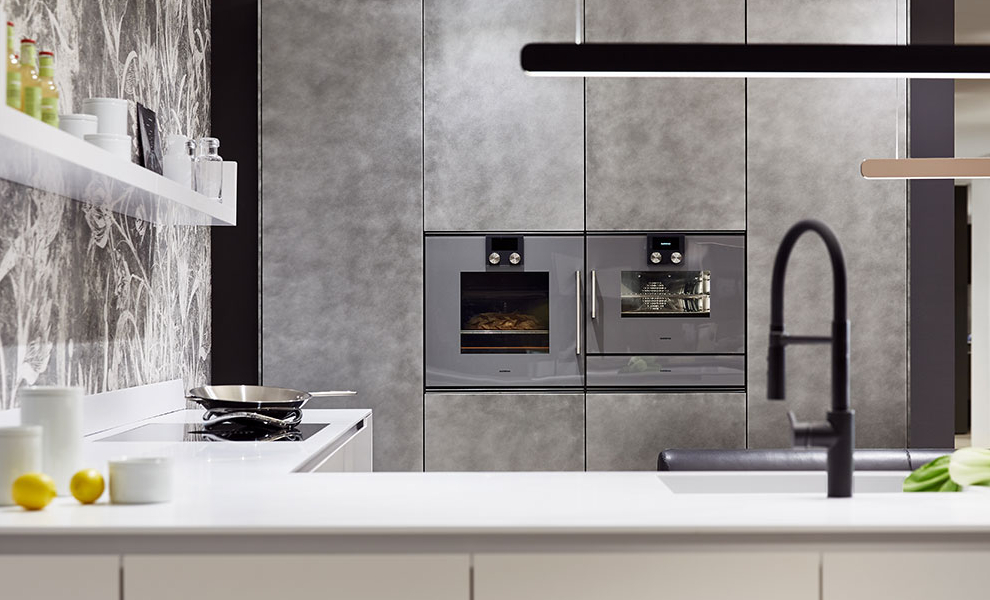 Offene helle L-Küche mit Spüle und Herd, Graue Wandschränke mit Küchengeräten  Offene helle L-Küche mit Spüle und Herd, Graue Wandschränke mit Küchengeräten