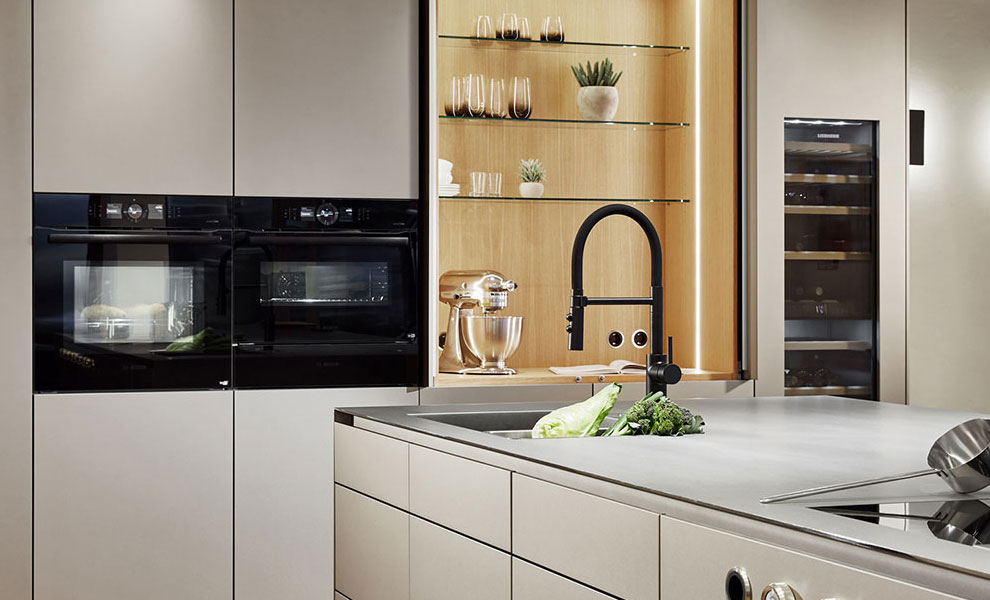 Große Kücheninsel mit Küchengeräten und an der Wand liegenden Schränken Große Kücheninsel mit Küchengeräten und an der Wand liegenden Schränken