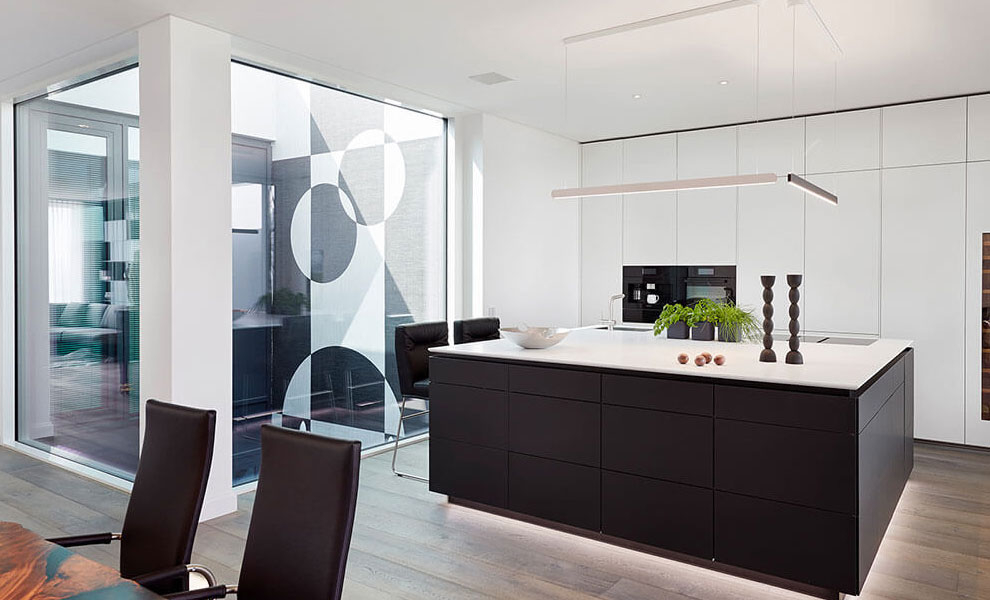 Schwarze Kücheninsel mit Weißer Arbeitsfläche und Weißen Schränken mit Küchengeräten Schwarze Kücheninsel mit Weißer Arbeitsfläche und Weißen Schränken mit Küchengeräten