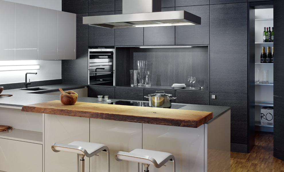 Weiße L-Küche mit Dunkler Arbeitsfläche, Theke, weiße Hängeschränke und Schwarzen Schränken Weiße L-Küche mit Dunkler Arbeitsfläche, Theke, weiße Hängeschränke und Schwarzen Schränken