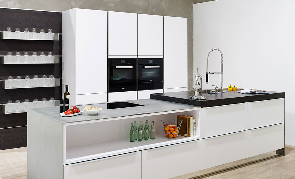 Helle Kücheninsel mit zweiteiliger Arbeitsplatte und einen weißen Wandschrank 