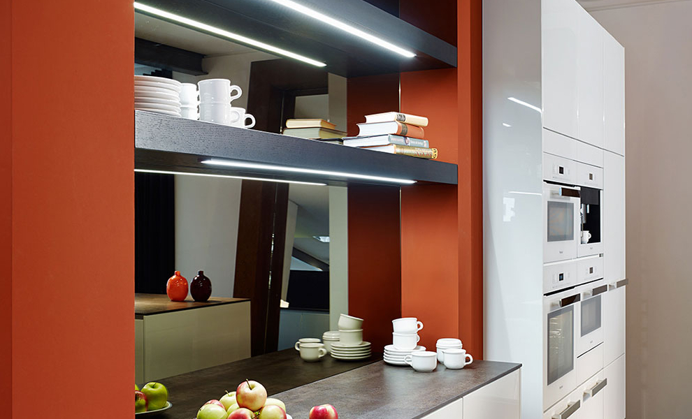 Wand in Rot mit Ablage, Weißen Schränken und Küchengeräten Wand in Rot mit Ablage, Weißen Schränken und Küchengeräten