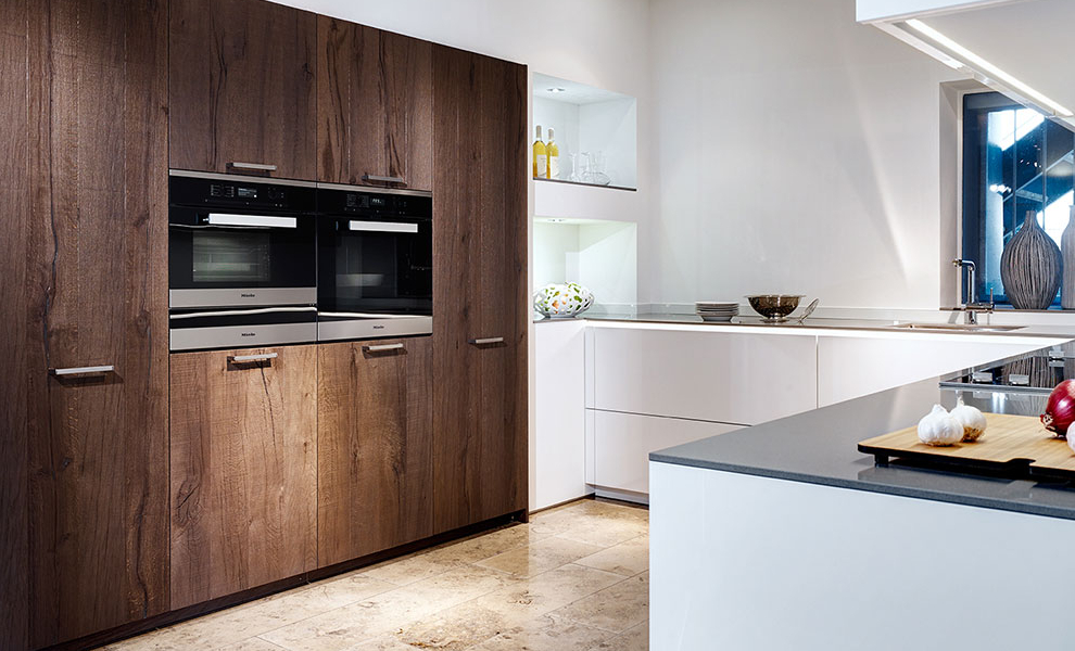 Große Helle L-Küche mit anliegenden Schränken aus Dunklen Naturholz und Küchengeräten Große Helle L-Küche mit anliegenden Schränken aus Dunklen Naturholz und Küchengeräten