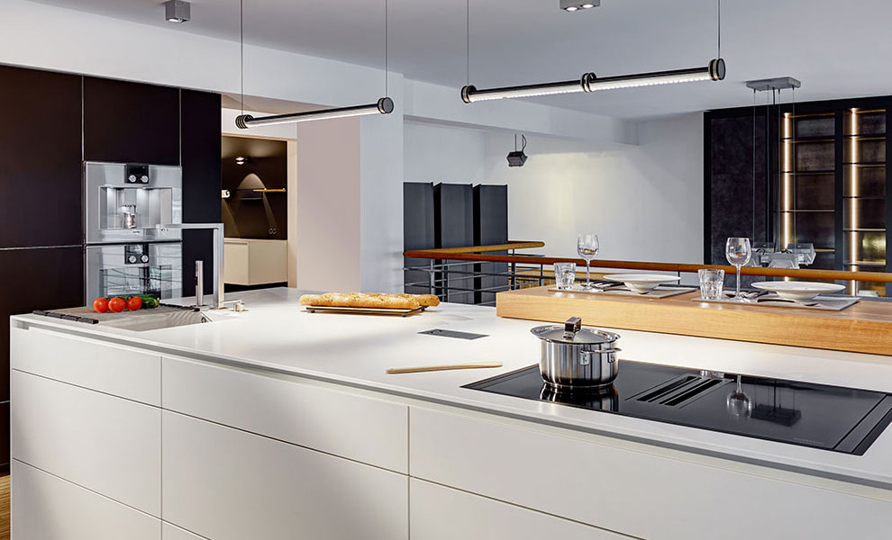 Kücheninsel in weiß mit Küchengeräten, mit schwarzen Wandschränken 
