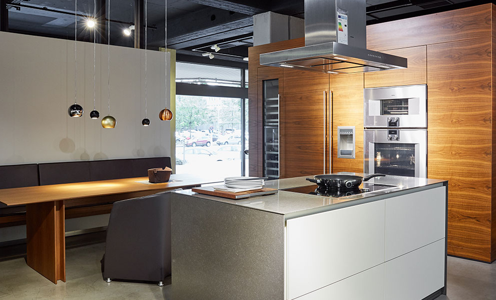 Helle Kücheninsel mit Herd und Schränken, Raumtrenner mit Naturholz und Küchengeräten Helle Kücheninsel mit Herd und Schränken, Raumtrenner mit Naturholz und Küchengeräten