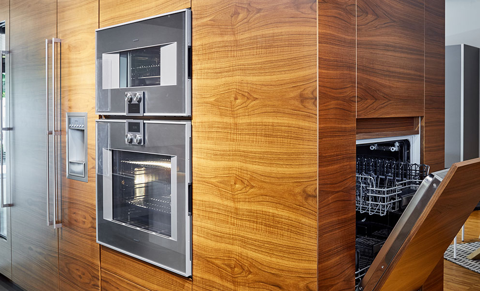 Raumtrenner mit Naturholzfronten und integrierten Küchengeräten Raumtrenner mit Naturholzfronten und integrierten Küchengeräten